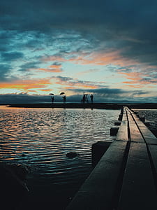 silhouette of people standing on dock thumbnail