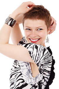 smiling woman wearing black and white top with hands on head thumbnail