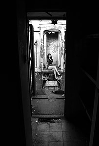 grayscale of woman sitting on camper trailer during daytime thumbnail