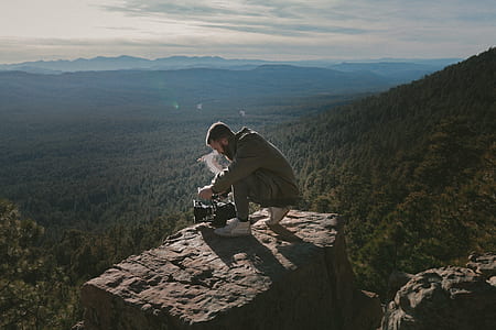 man in gray jacket on hill top during daytime thumbnail