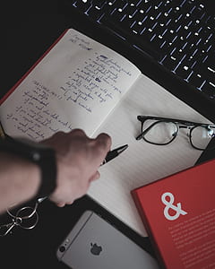 person holding pen and notebook thumbnail
