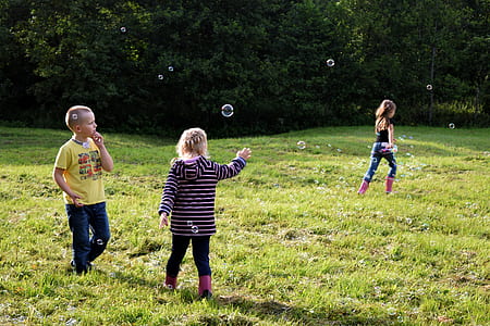 children playing bubbles on lawn field thumbnail