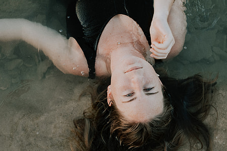 woman in tank top lying on body of water thumbnail