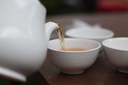 person holding a teapot pouring tea in a teacup thumbnail