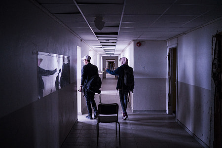 two person walking on white corridor thumbnail