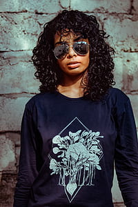 woman wearing Aviator-style sunglasses posing in front wall thumbnail
