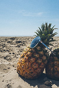 sunglasses and pineapple on white sand thumbnail