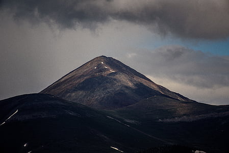 low-angle photography of mountain over black clouds thumbnail