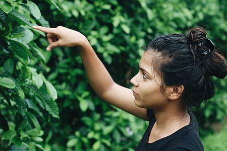 shallow focus photography of woman touching leaves thumbnail