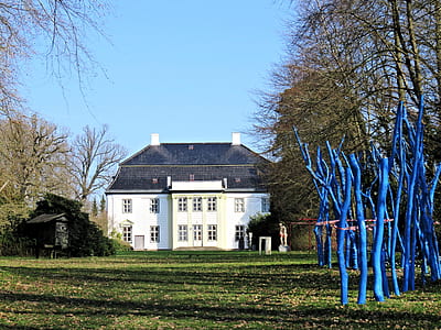 white and black house across grass field thumbnail