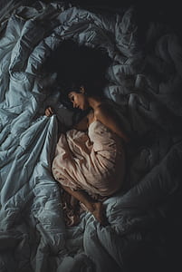 aerial photography of woman lying on gray textile thumbnail