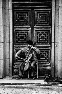 man playing double bass in front of large door thumbnail