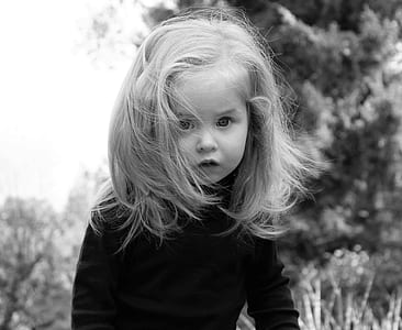 girl in long-sleeved shirt standing on grass field thumbnail