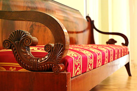 close-up photography of brown wooden framed sofa with pink and yellow fabric cushion thumbnail