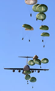 Army Paratroopers Practicing Parachute Drop from a Military Air Plane during Daytime thumbnail