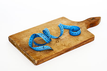 Blue Measuring Tape on Brown Wooden Chopping Board thumbnail