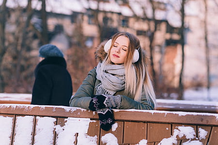women's gray coat with gray scarf on fence thumbnail