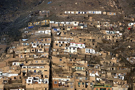 white and brown concrete house beside mountain thumbnail