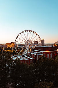 white Ferris wheel beside red building thumbnail