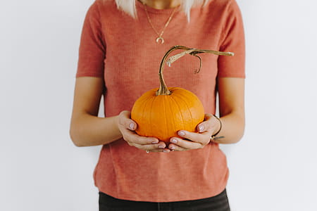 Women's hands in sweater are holding pumpkin thumbnail