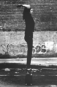 Grayscale Photo of Woman in Black Short-sleeved Shirt and Black Pants thumbnail
