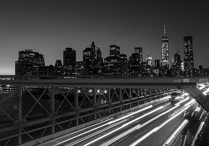 time-lapse grayscale photography of vehicles on bridge near the city thumbnail