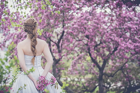 woman in white wedding dress surrounded by purple flowers thumbnail