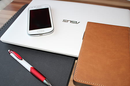 white Samsung Android smartphone on top of white laptop thumbnail