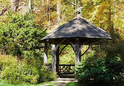 A wooden gazebo in a backyard garden. thumbnail