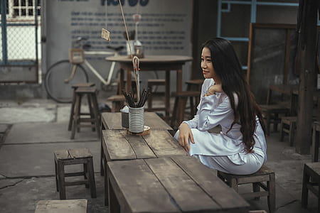 woman wearing white long-sleeved dress sitting on chair thumbnail