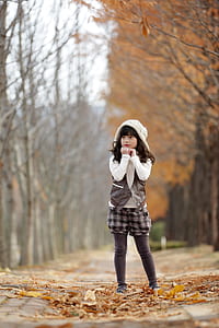 standing girl wearing white and brown hooded top at daytime thumbnail