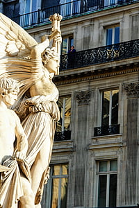 brown angel statue beside of building during daytime thumbnail