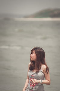 Woman Standing Near Body of Water thumbnail