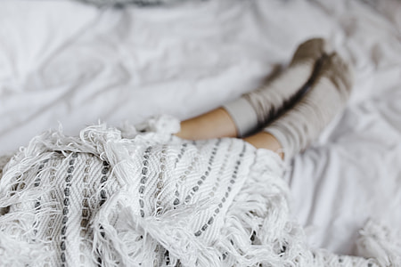 Soft photo of woman on the bed with the book and cup of coffee in hands thumbnail