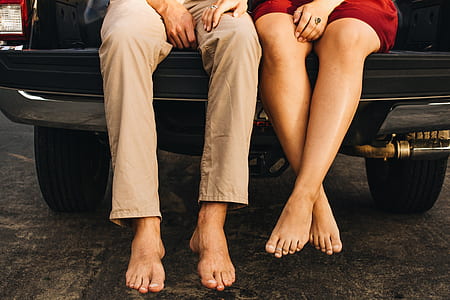 man and woman sitting on pickup truck tailgate close-up photo thumbnail