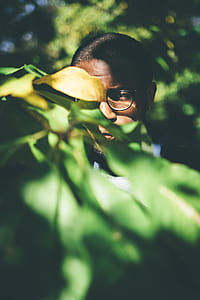 shallow focus photography of man looking green plant thumbnail