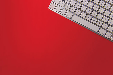 Wireless computer keyboard on a red background thumbnail