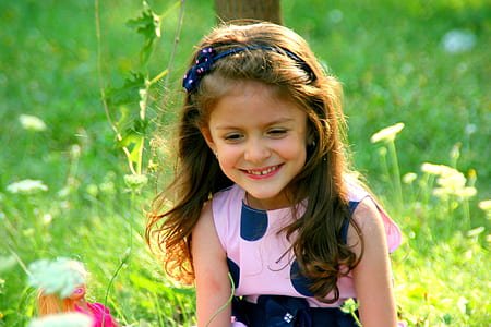 girl wearing pink and blue dress leaning on brown tree thumbnail