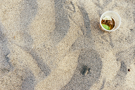 clear plastic cup on sand thumbnail