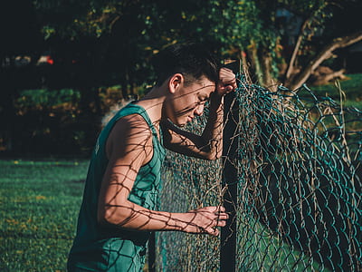 man leaning on fence thumbnail