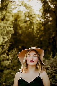 woman standing near green tree during daytime thumbnail