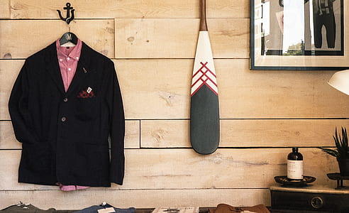 black suit jacket hanging near brown wooden wall thumbnail