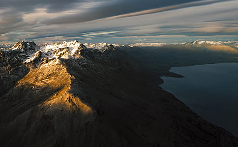 aerial photo of mountains beside the body of water thumbnail
