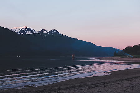 landscape photography of coastline near mountain alps thumbnail