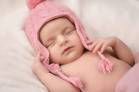 baby wearing pink knit bobble hat thumbnail
