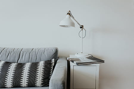 book on table with table lamp beside sofa thumbnail