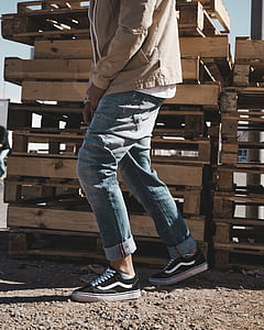 person wearing blue jeans beside pallets thumbnail