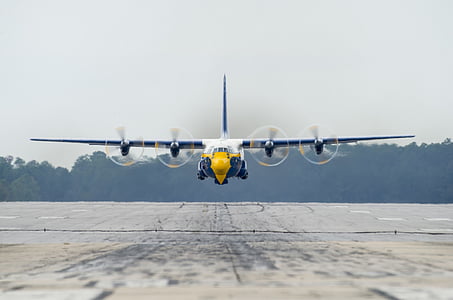 white, yellow, and blue airplane over gray pavement thumbnail