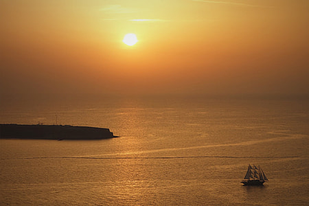 black boat on body of water under orange sunset thumbnail