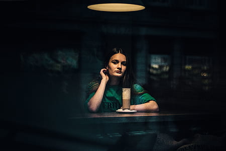 woman in front of brown liquid filled highball glass thumbnail